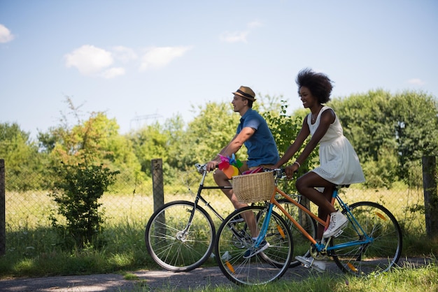 un jeune homme et une belle fille afro-américaine profitant d'une balade à vélo dans la nature par une journée d'été ensoleillée