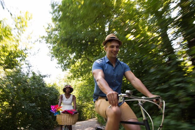 un jeune homme et une belle fille afro-américaine profitant d'une balade à vélo dans la nature par une journée d'été ensoleillée