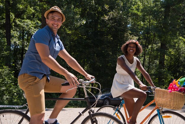 un jeune homme et une belle fille afro-américaine profitant d'une balade à vélo dans la nature par une journée d'été ensoleillée