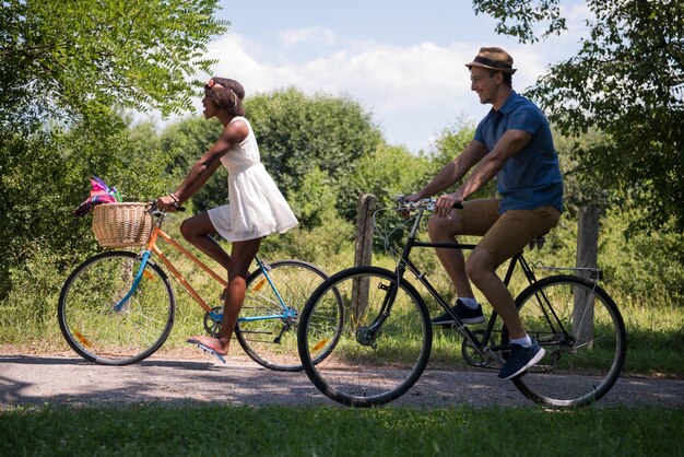 un jeune homme et une belle fille afro-américaine profitant d'une balade à vélo dans la nature par une journée d'été ensoleillée