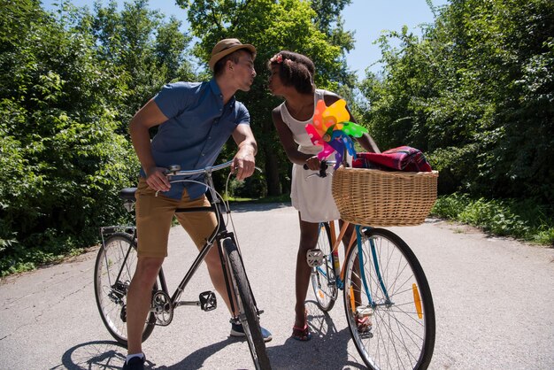 un jeune homme et une belle fille afro-américaine profitant d'une balade à vélo dans la nature par une journée d'été ensoleillée