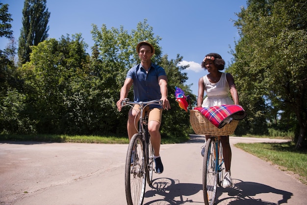 Photo un jeune homme et une belle fille afro-américaine profitant d'une balade à vélo dans la nature par une journée d'été ensoleillée