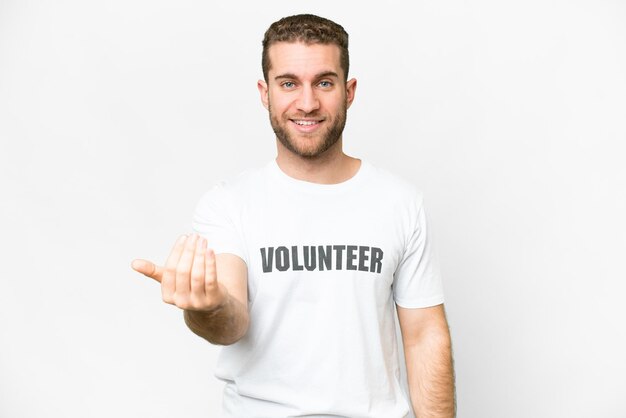 Jeune homme bénévole sur fond blanc isolé invitant à venir avec la main Heureux que vous soyez venu