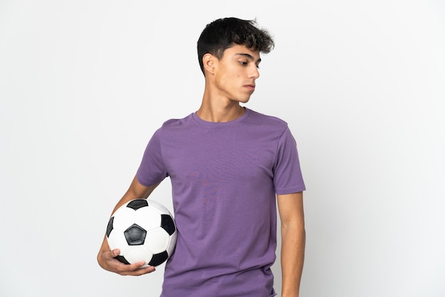 Jeune homme sur blanc isolé avec ballon de foot