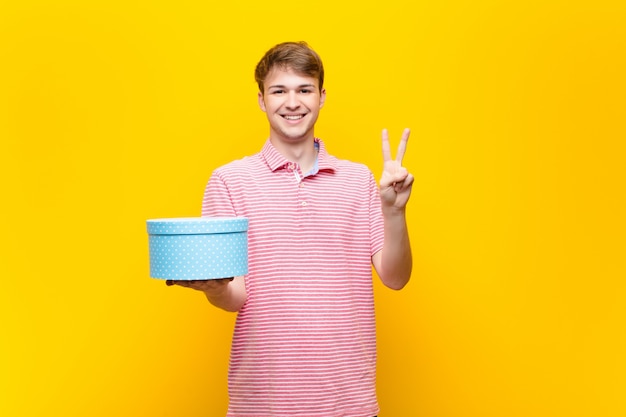 Jeune homme blond avec une boîte-cadeau