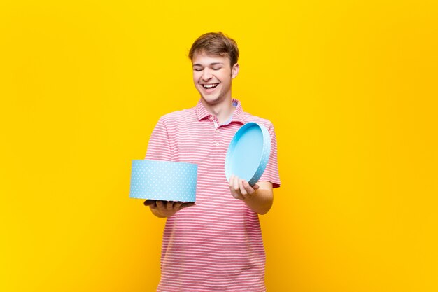 Jeune homme blond avec une boîte-cadeau