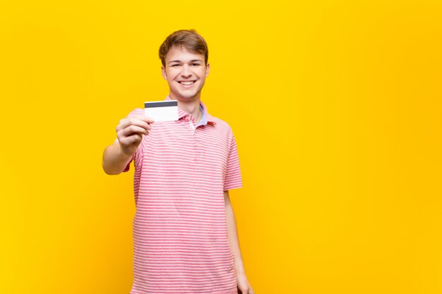 Jeune homme blond avec une carte de crédit