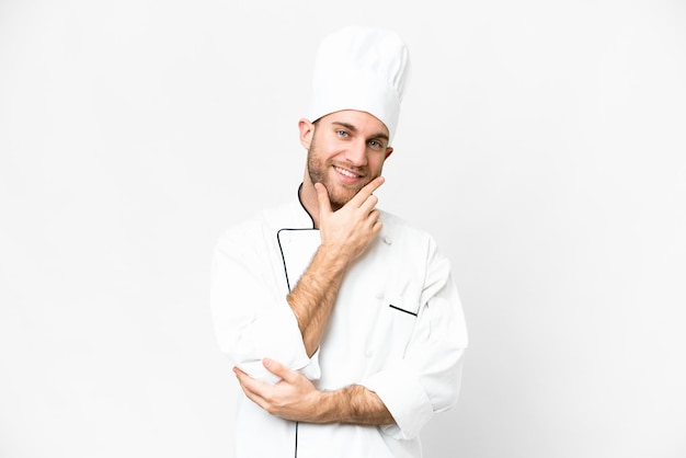 Jeune homme blond Chef sur fond blanc isolé souriant