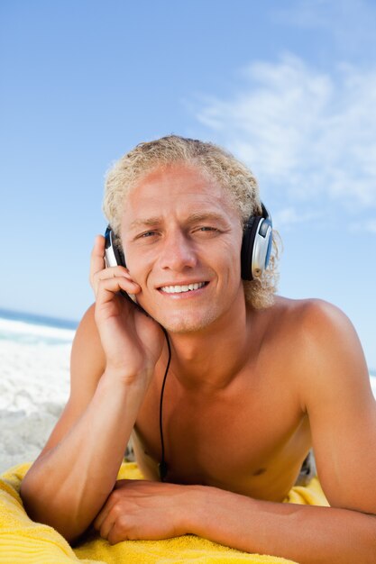 Jeune homme blond écoutant attentivement de la musique avec son casque