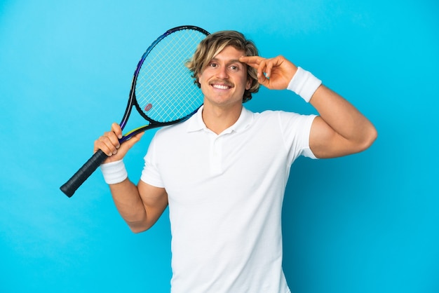 Jeune homme blond isolé jouant au tennis