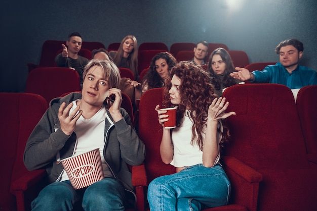 Jeune Homme Blond Parle Au Téléphone Pendant La Projection Du Film.