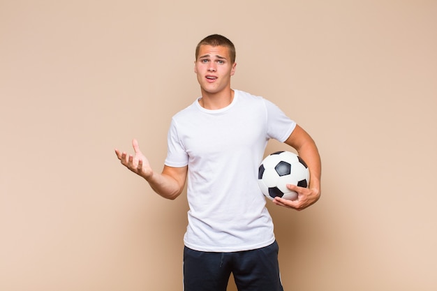 Jeune homme blond à la recherche désespérée et frustrée, stressée, malheureuse et agacée, criant et hurlant