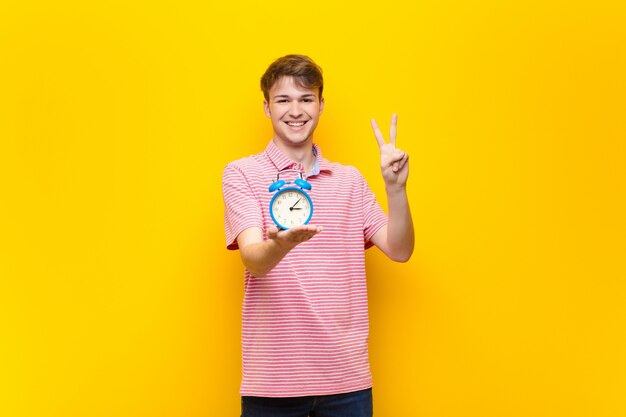 Jeune homme blond avec un réveil