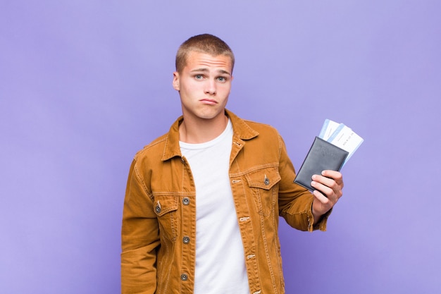 Jeune homme blond se sentant triste et pleurnichard avec un regard malheureux, pleurant avec une attitude négative et frustrée