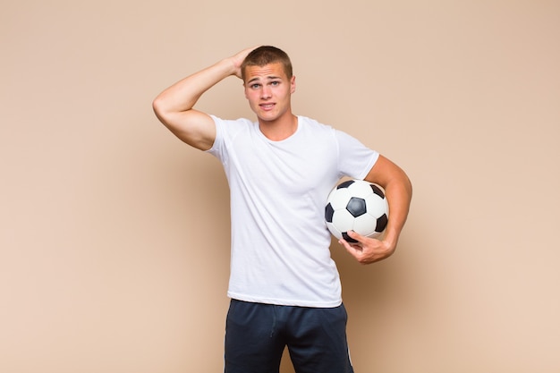 Jeune homme blond stressé, inquiet, anxieux ou effrayé, les mains sur la tête, paniquant à l'erreur