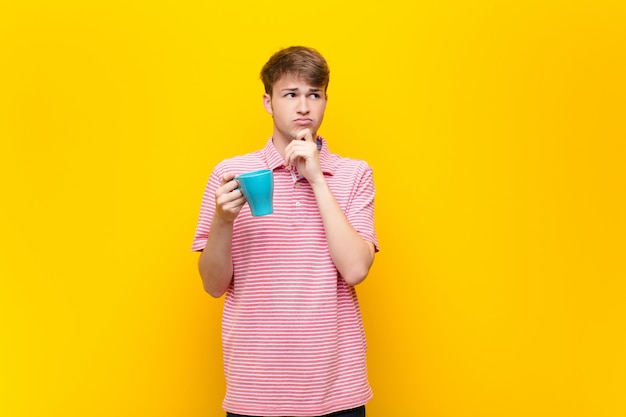 Jeune homme blond avec une tasse de café