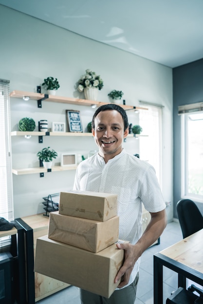 Jeune homme avec des boîtes au bureau