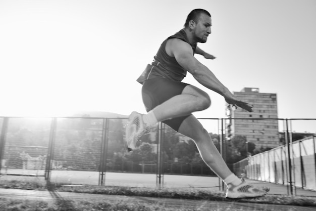 jeune homme en bonne santé courir sur une piste de sport de course athlétique et représentant le concept de tri et de vitesse