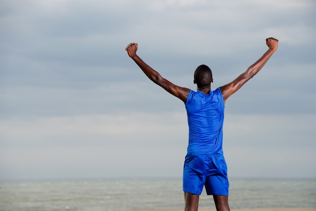 Jeune homme en bonne santé, debout sur la plage