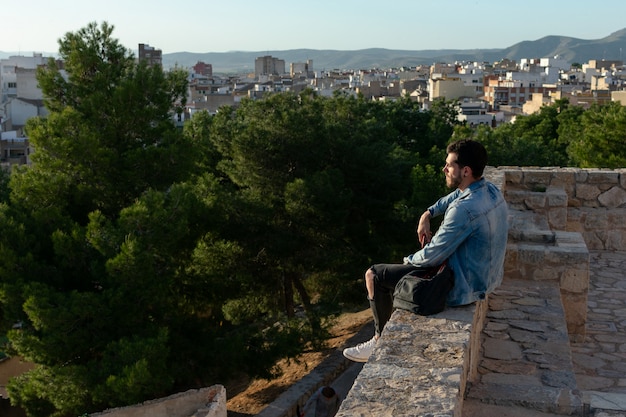 Jeune homme avec bonnet et veste cherche la ville. Concept de style de vie, modèle.