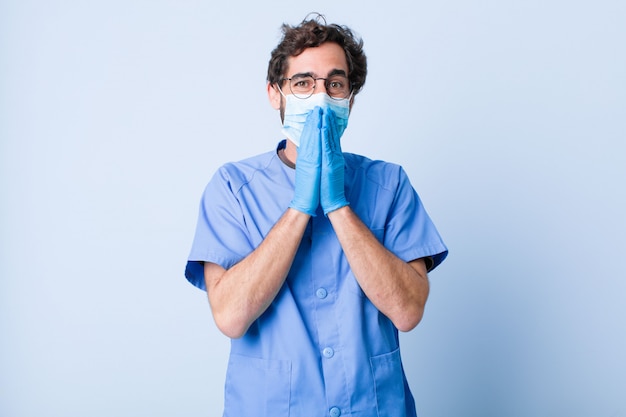 Jeune homme à la bouche heureuse, gaie, chanceuse et surprise couvrant les deux mains. concept de coronavirus