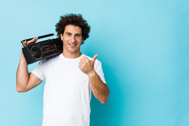 Jeune homme bouclé caucasien tenant un blaster guetto