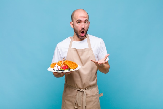 Jeune homme boulanger avec des gaufres