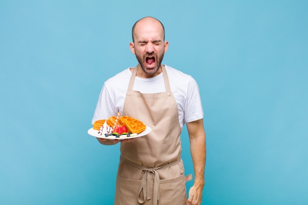 Jeune homme boulanger avec des gaufres