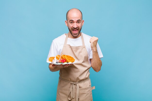 Jeune homme boulanger avec des gaufres