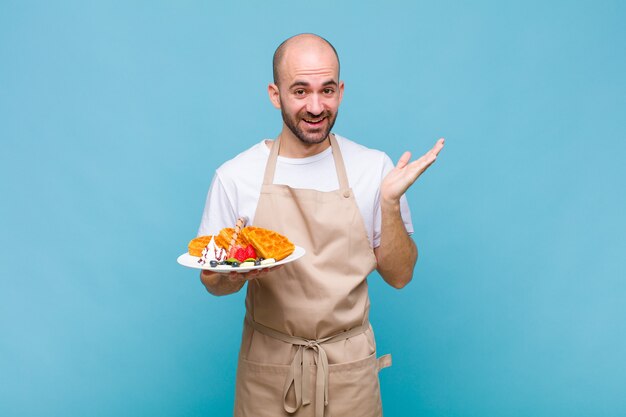 Jeune homme boulanger avec des gaufres