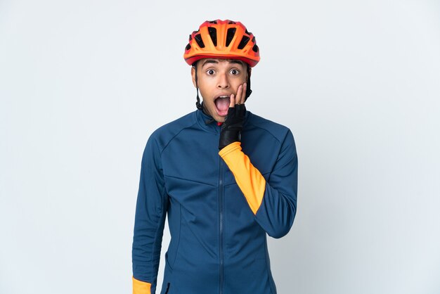 Jeune homme brésilien cycliste isolé sur un espace blanc avec surprise et expression faciale choquée