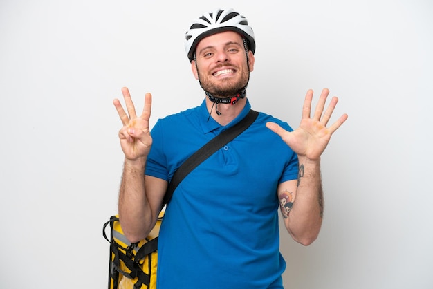 Jeune homme brésilien avec sac à dos thermique isolé sur fond blanc comptant huit avec les doigts