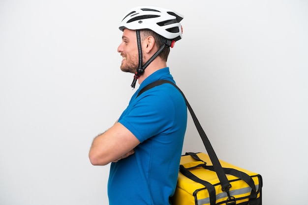 Jeune homme brésilien avec sac à dos thermique isolé sur fond blanc en position latérale