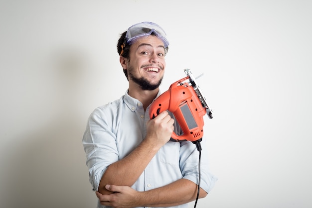 jeune homme bricolage travaillant avec une scie électrique