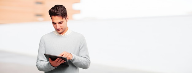 Jeune homme bronzé avec une tablette tactile