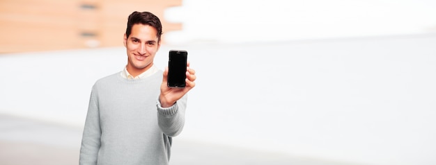 Jeune homme bronzé avec un téléphone intelligent à écran tactile