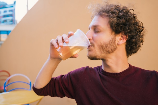 Jeune homme buvant de la bière.