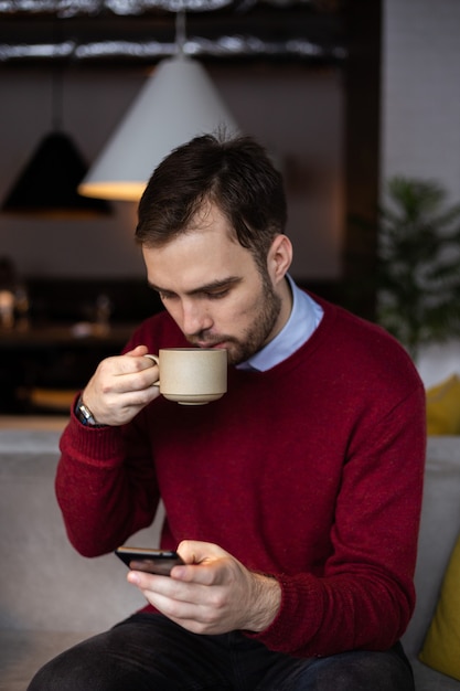 Jeune homme buvant du café dans un café