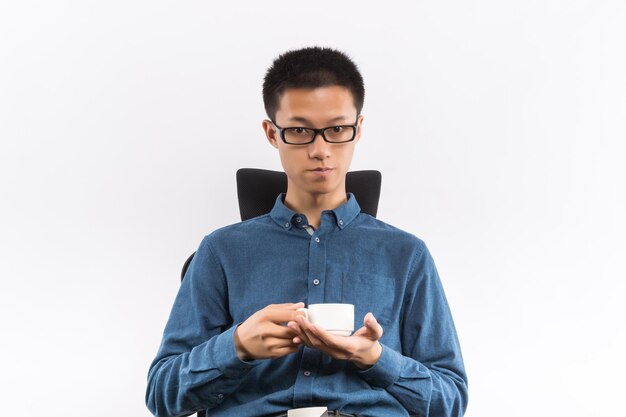 Jeune homme buvant une tasse de porcelaine de thé naturel asiatique