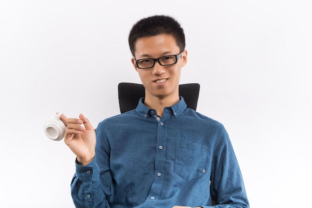 Jeune homme buvant une tasse de porcelaine de thé naturel asiatique