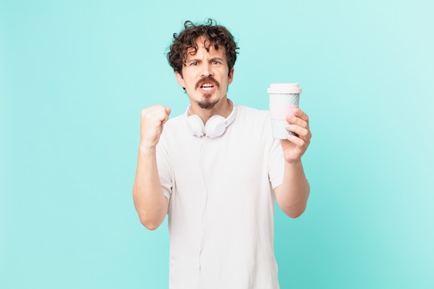 Jeune homme avec un café criant agressivement avec une expression fâchée