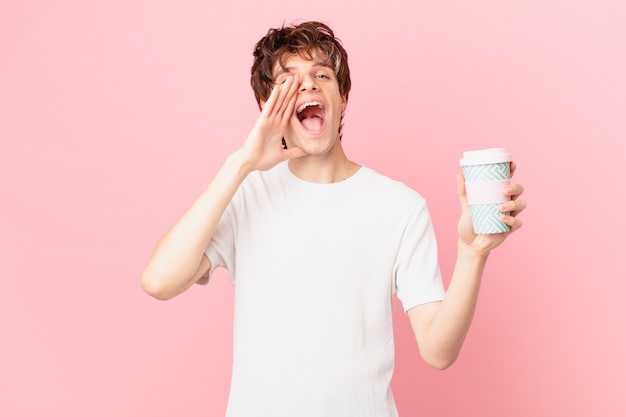 Jeune homme avec un café se sentant heureux, donnant un grand cri avec les mains à côté de la bouche