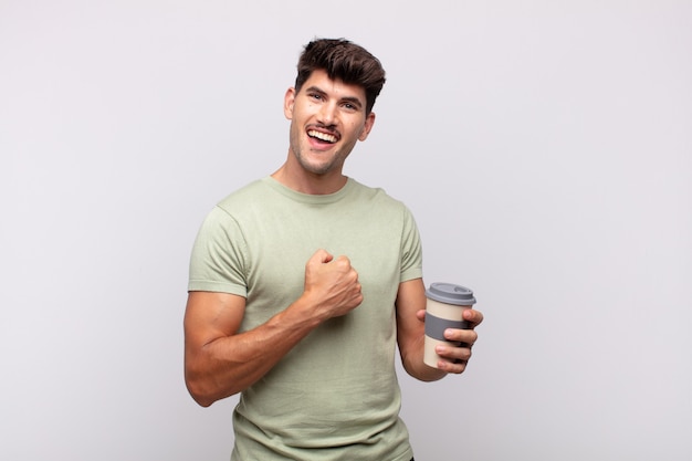 Jeune homme avec un café se sentant heureux