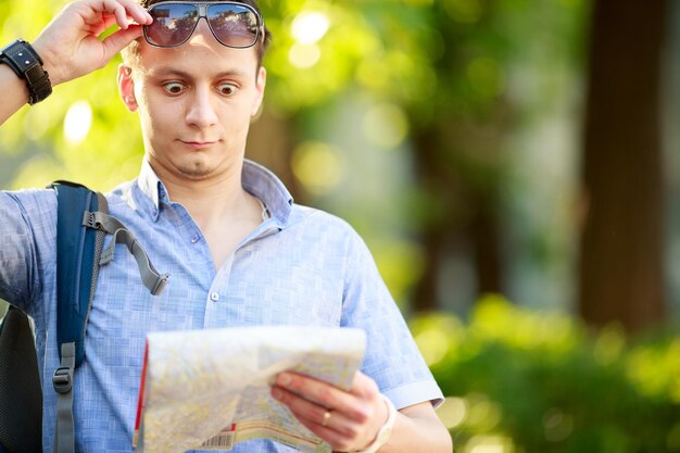 Jeune homme avec une carte à l'extérieur