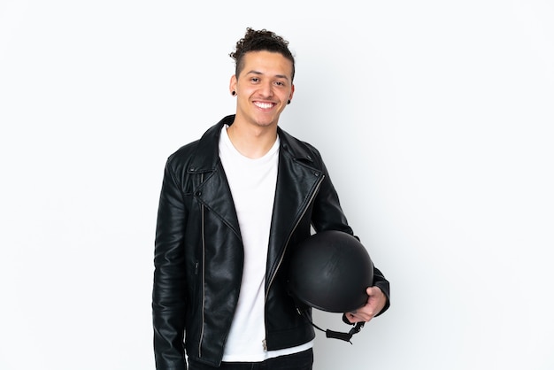 Jeune homme avec un casque de moto sur un mur blanc isolé