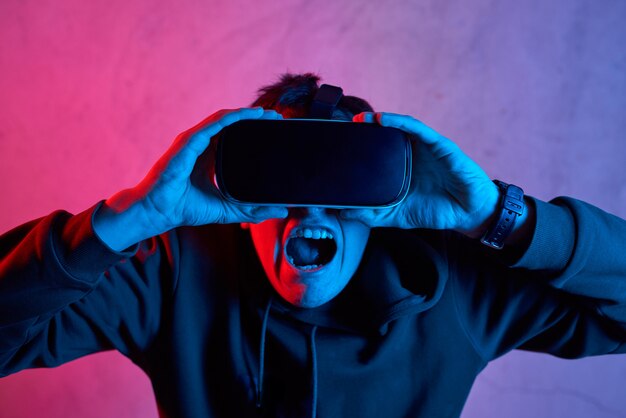 Jeune homme avec un casque de réalité virtuelle criant à la caméra