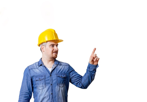 Un jeune homme avec un casque de sécurité pointe vers un espace de copie