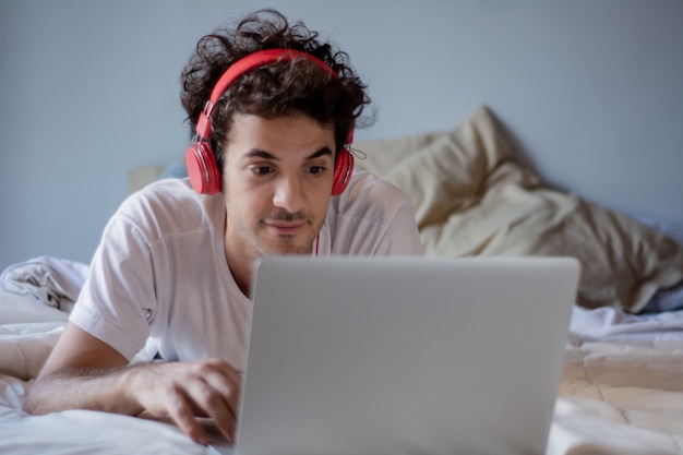 Jeune homme avec un casque et utilisant un ordinateur portable