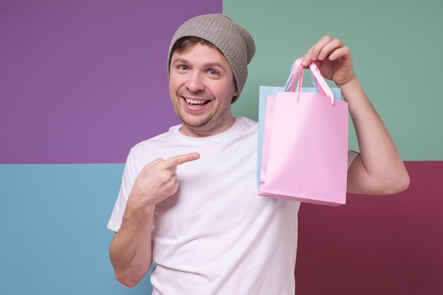 Jeune homme caucasien avec achat tenant un petit paquet de papier