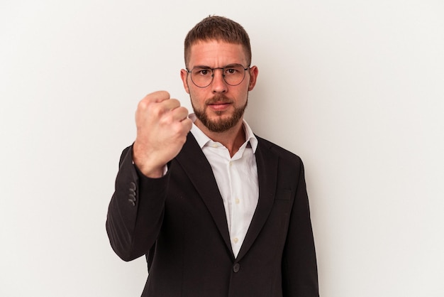 Jeune homme caucasien d'affaires isolé sur fond blanc montrant le poing à la caméra, expression faciale agressive.